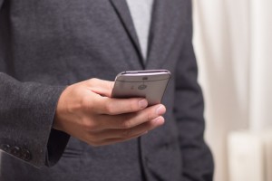 businessman-standing-in-office-text-messaging